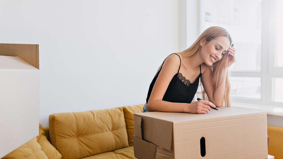 How to pack for a move? pretty young woman labeling cardboard box holding RX68VMB 1170x658 1