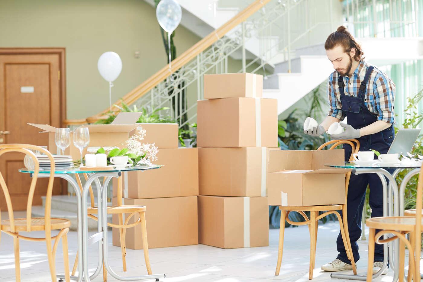 10 reasons to hire professional packers and movers young mover unpacking boxes in new restaurant 2021 04 02 20 38 16 utc
