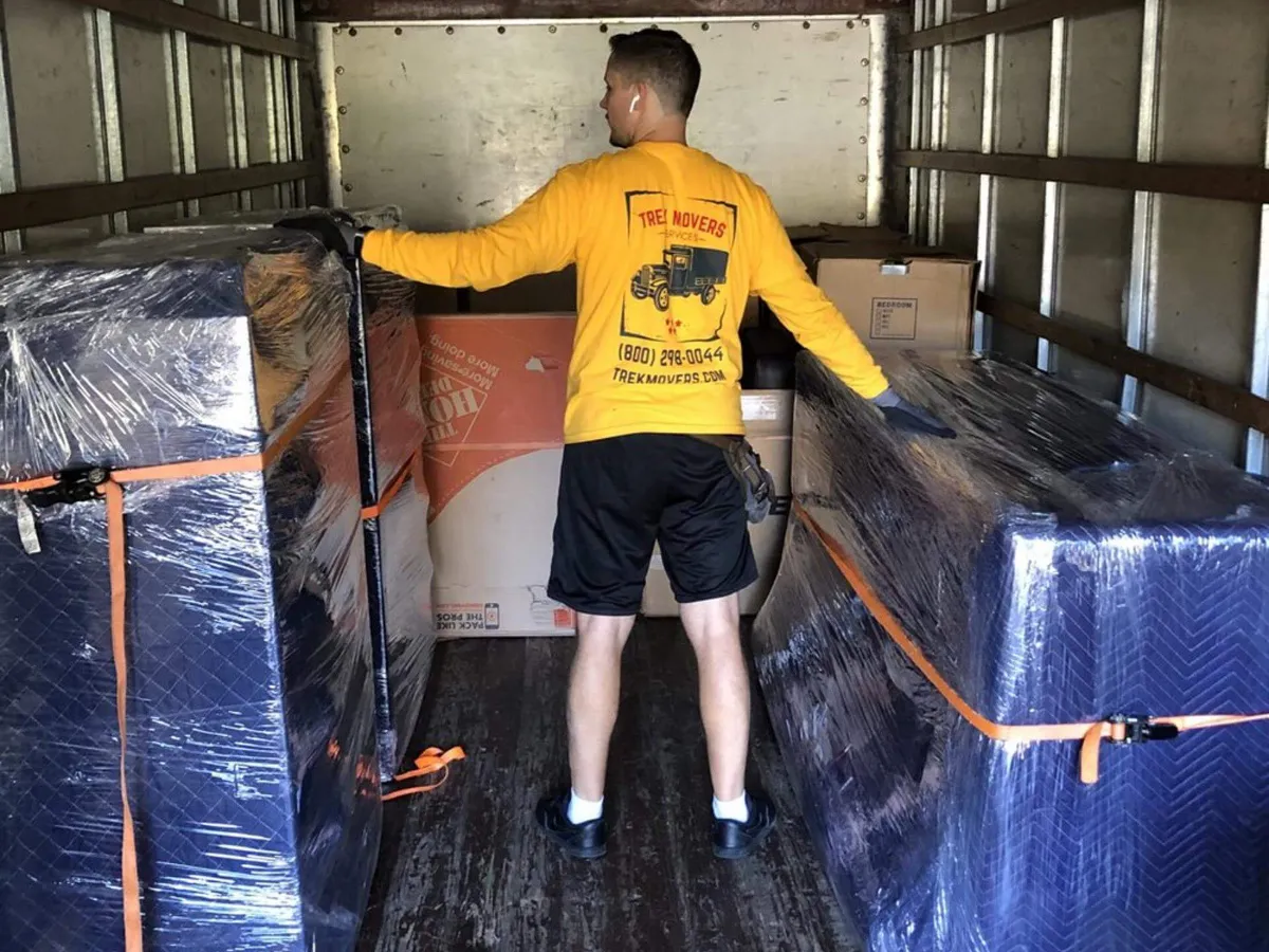 Professional mover arranging boxes in the moving truck. California moving company. Trek Movers
