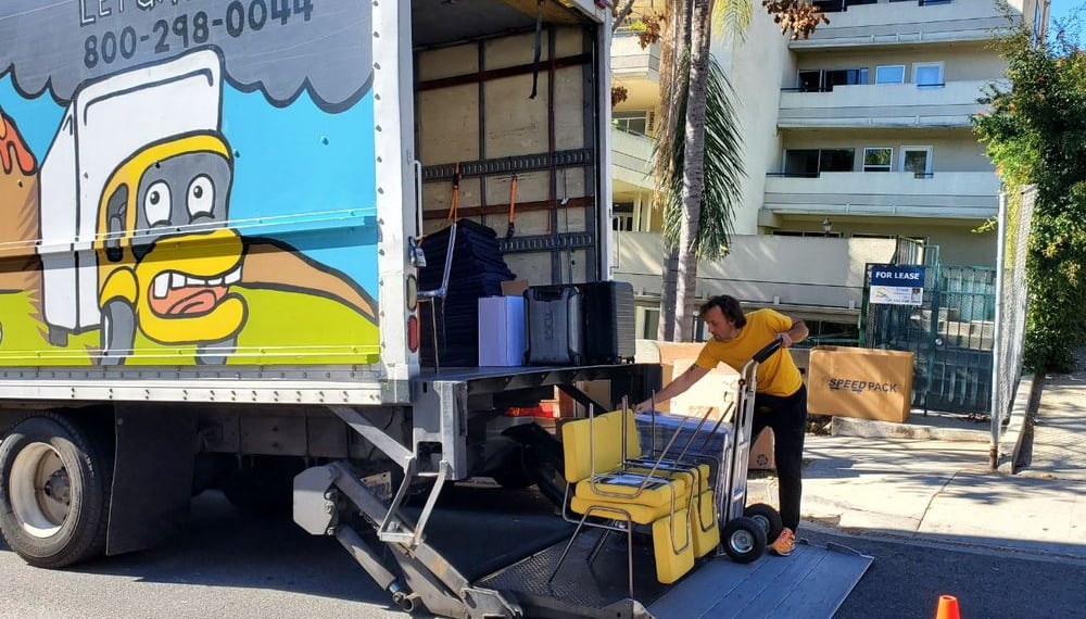 Man loading chairs into a moving truck, TrekMovers
