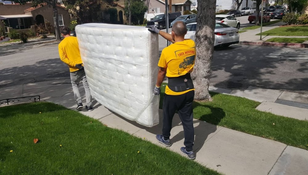 Two men carrying a mattress during a move, TrekMovers