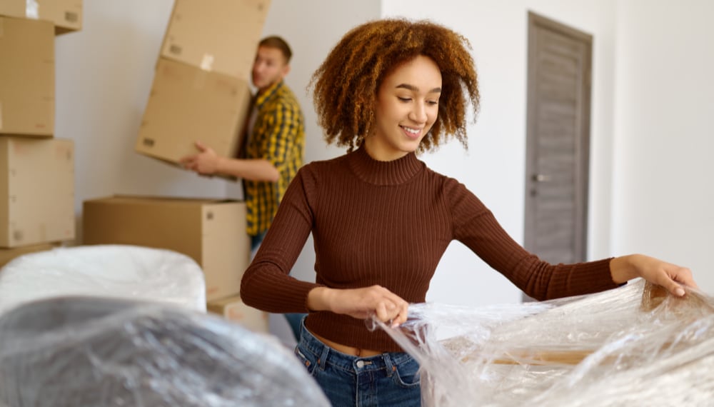 Woman packing belongings into boxes for a move, TrekMovers