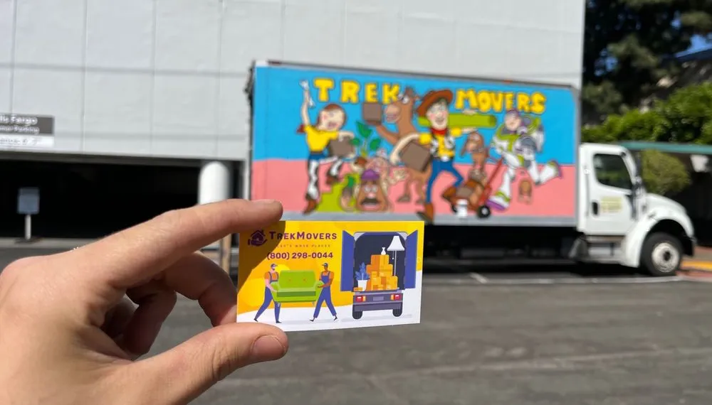 Moving truck parked in the background with a business card in focus, TrekMovers
