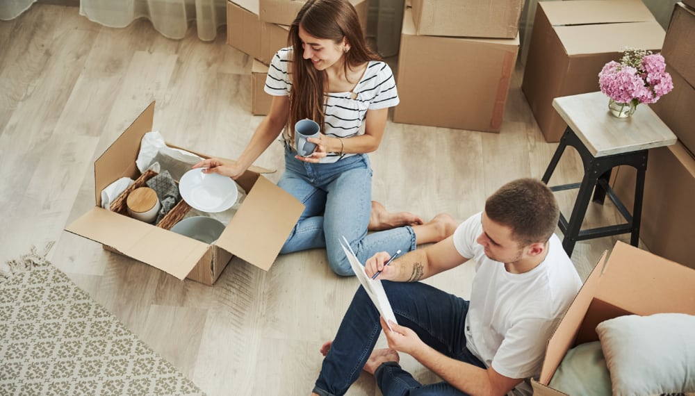 Woman carefully packing dishes into boxes for moving, TrekMovers