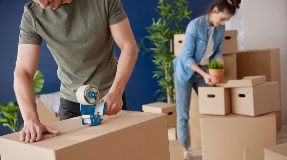 How to Pack for a Move — A Complete Guide couple packing cardboard boxes while moving house 2021 08 28 05 51 33 utc
