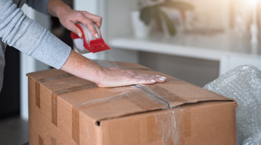 How to Pack for a Move — A Complete Guide woman is packing boxes getting ready for moving 2022 08 01 04 21 19 utc