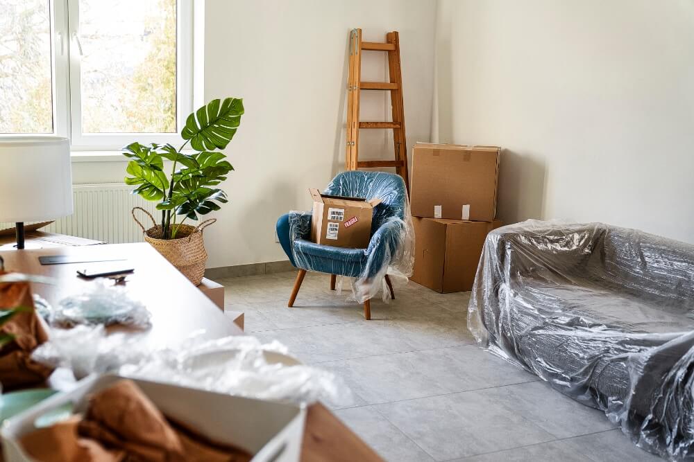 Furniture Moving Tips — A Comprehensive Guide empty flat with carton boxes and furnitures covere 2023 11 27 05 16 49 utc