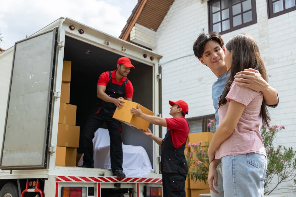 How to Choose the Right Long-Distance Moving Company young couple checks with two movers unloading boxe 2023 11 27 05 06 01 utc