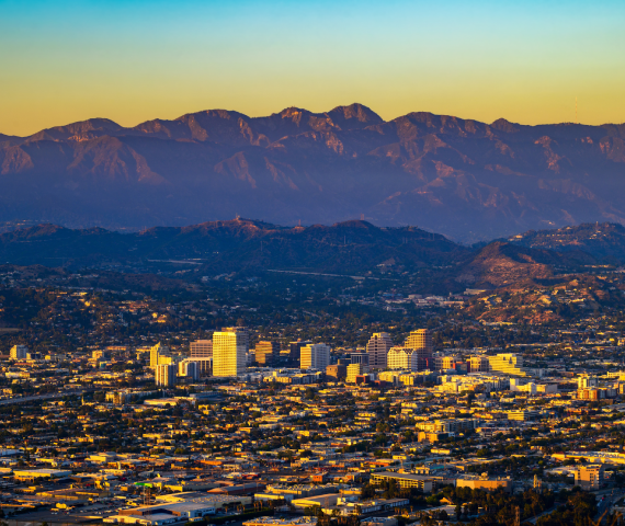 Aerial view of downtown Glendale and the San Gabriel Mountains in California, at sunset.