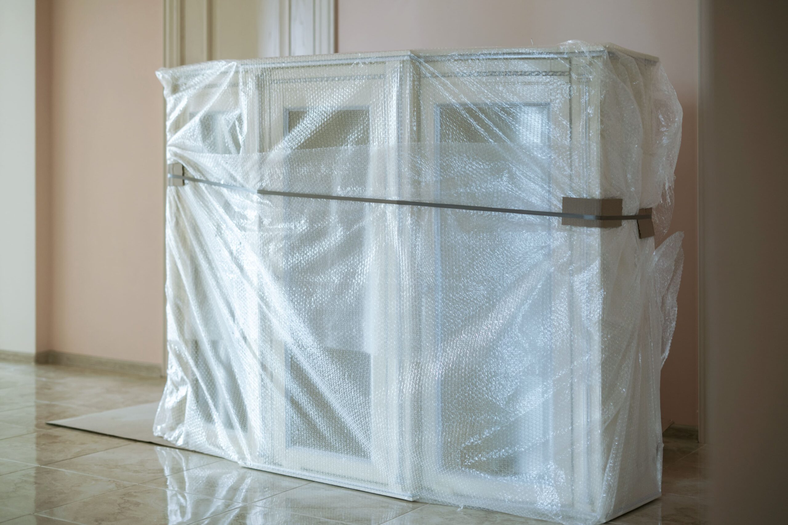 New furniture delivered to the new flat apartment in a plastic protective material.