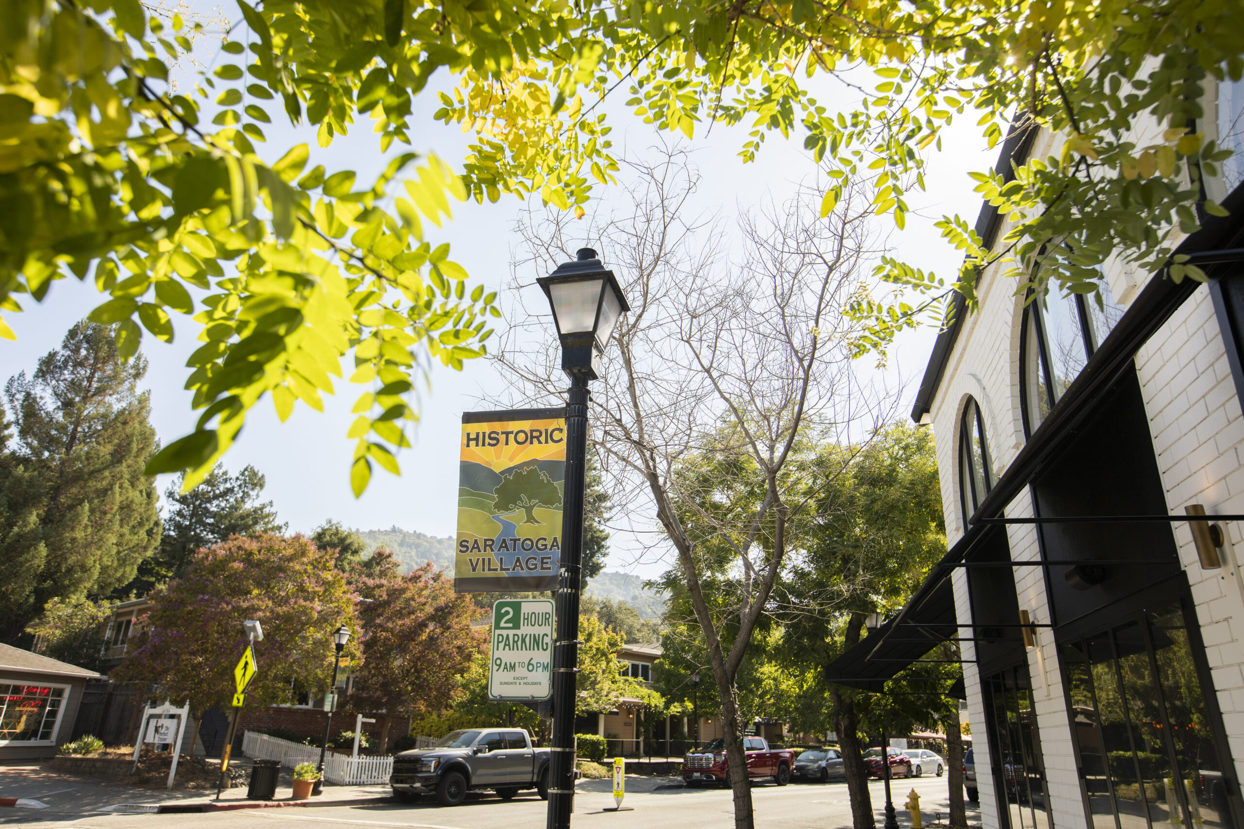 Historic Village of Saratoga, California, with the afternoon sun shining on historic downtown buildings and autumn trees.
