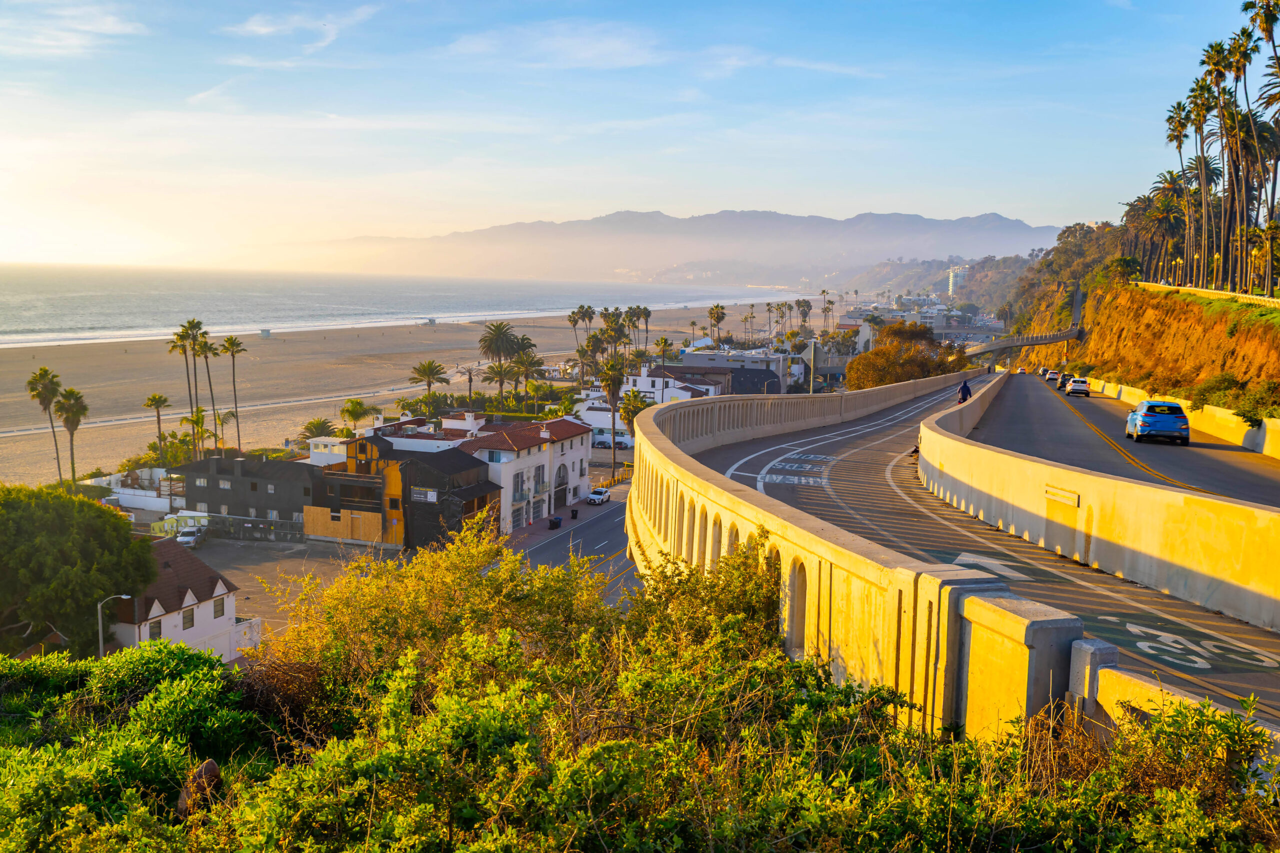 Sunset view of Santa Monica coastline and Pacific Coast Highway with beachside apartments and condos.