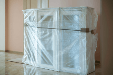 New furniture delivered to the new flat apartment in a plastic protective material.