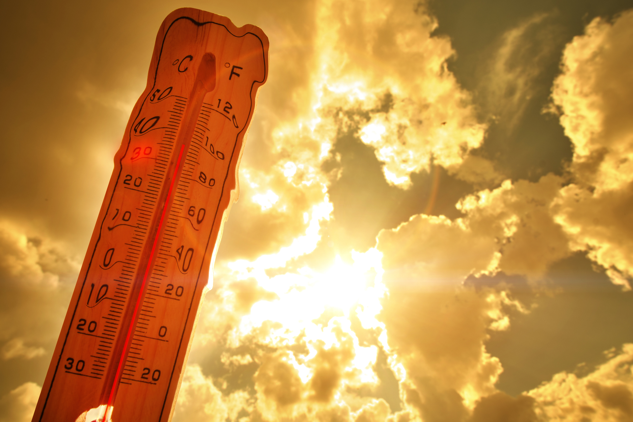 Melting street thermometer against bright summer sun.
