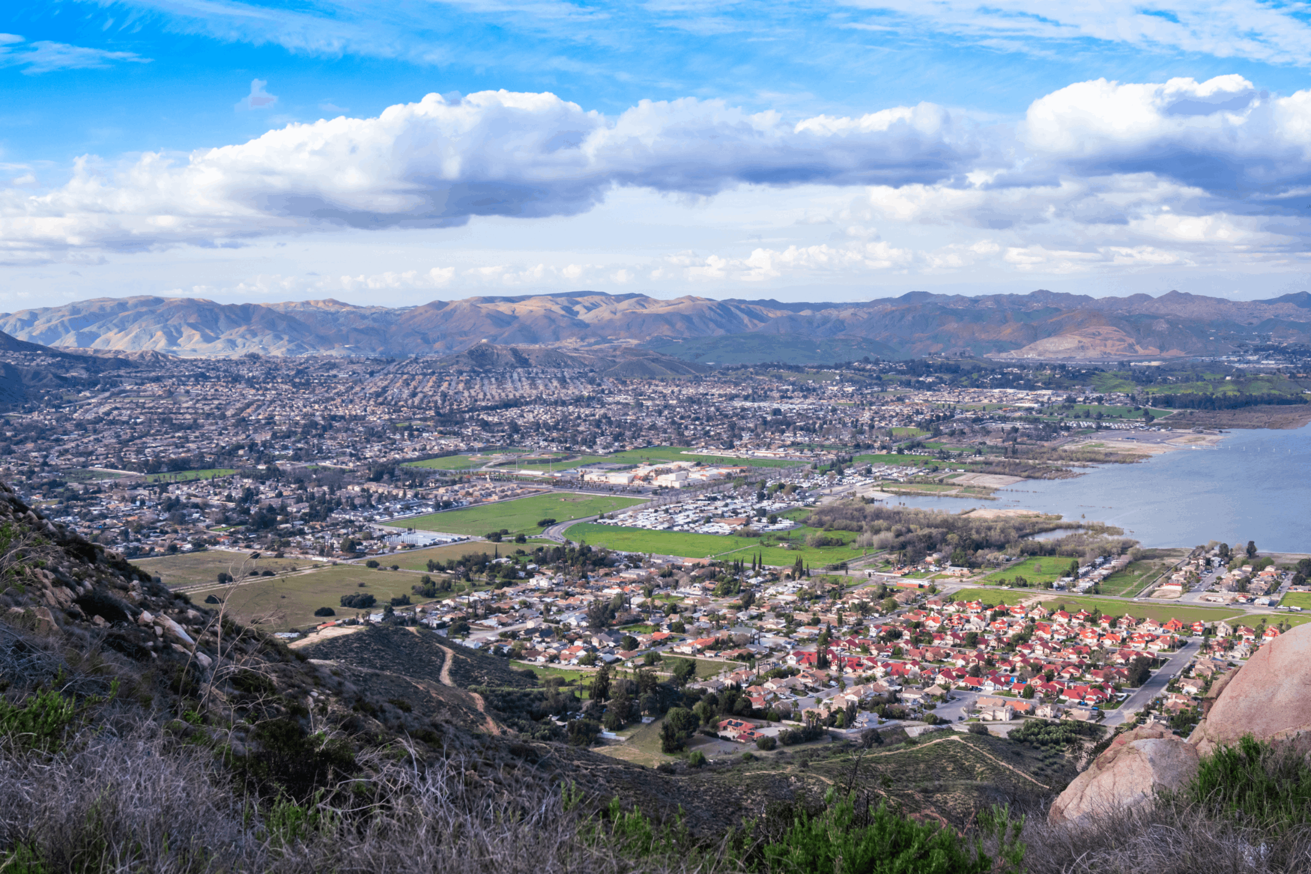 Residential houses in a valley by the lake with mountains on the background. Panoramic view on the city of Lake Elsinore, Southern California USA.